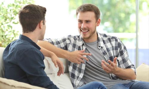 Two seated students in professional attire engaged in conversation.