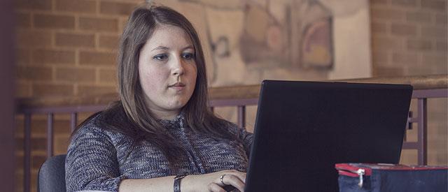 A girl looking at information on a laptop